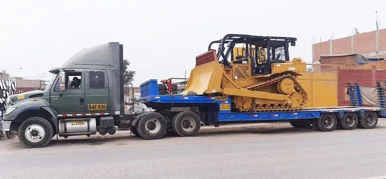 Truck carrying a crawler tractor on a lowboy